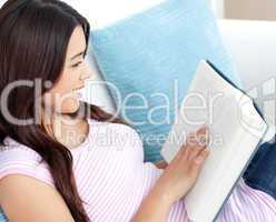 Attractive woman reading a book on sofa