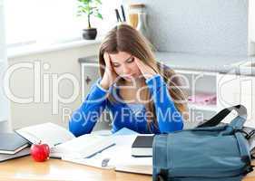 Happy female teenager studying in the kitchen