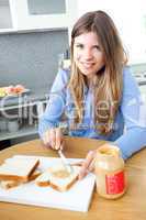 Relaxed woman having breakfast in kitchen