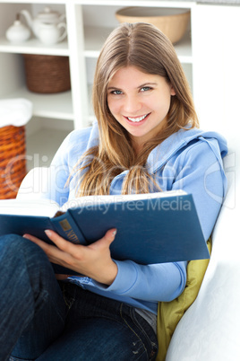 Happy woman reading a book in the living room