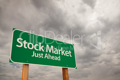 Stock Market Green Road Sign Over Storm Clouds