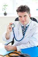 Portrait of a handsomemale doctor holding a stethoscope