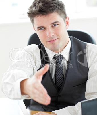 Charming  young businessman holding out his hand