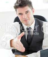 Charming  young businessman holding out his hand