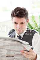 Concentrated businessman reading a newspaper