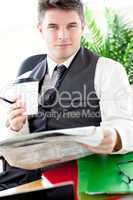 Serious businessman drinking a coffee while reading a newspaper