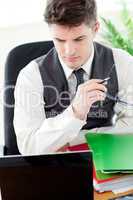 Worried male doctor looking at his laptop