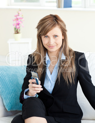 Serious attractive businesswoman using her mobile phone