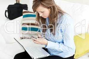 Young businesswoman with laptop and cellphone