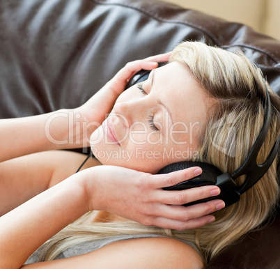 Relaxed woman with headphones on lying on a sofa