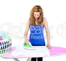 Glowing woman ironing her clothes on a ironing board