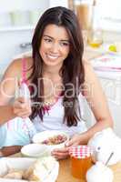 Smiling woman eating muesli with fruits