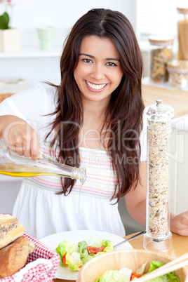 Jolly woman prepare a salad smiling at the camera