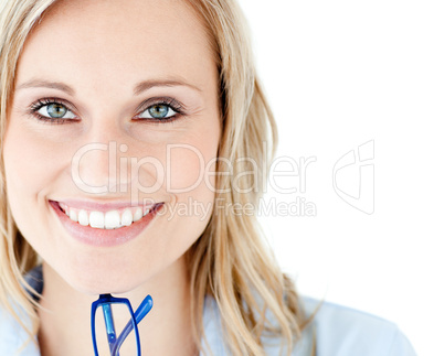 Close-up of a smiling woman holding glasses looking at the camer