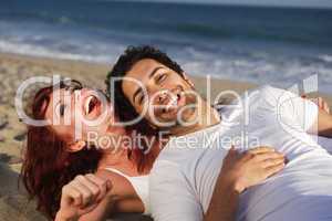 Young couple at the beach laughing