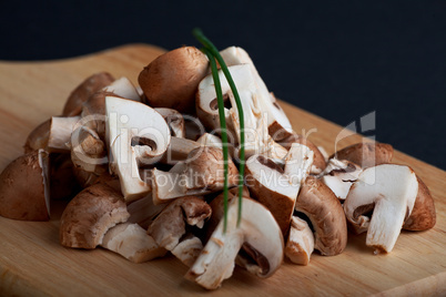 Haufen von gehackten Champignons auf einem Holzbrett