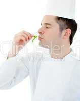 Charming young cook with closed eyes holding a herb