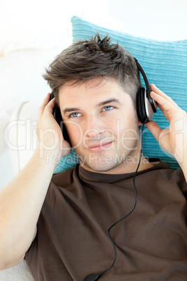 Smiling young man with headphones listening to music