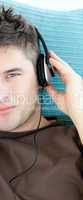 Charming young man listening to music with headphones