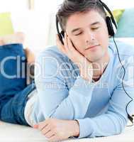 Relaxed man lying on the floor listening to music