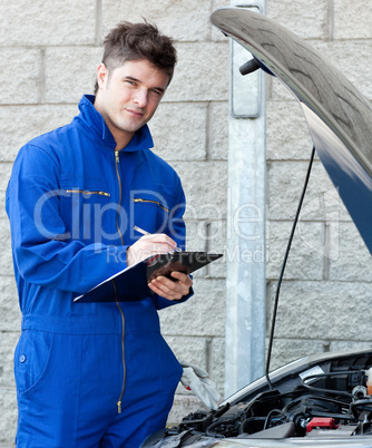 Attractive mechanic writing on a clipoard