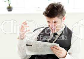 Portrait of a annoyed businessman reading a newspaper