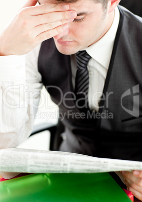 Thinking businessman reading a newspaper