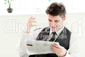 Portrait of a positive businessman reading a newspaper siiting i