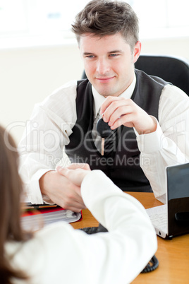 Young attractive salesman giving car's key to his customer