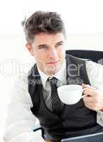 Confident young businessman with a laptop holding a coffee