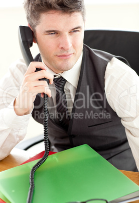 Self-assured businessman talking on phone at office