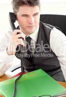 Self-assured businessman talking on phone at office