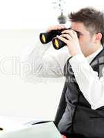 Close-up of a young businessman looking through binoculars isola