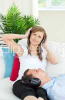 Cheerful woman listening to music with her boyfriend