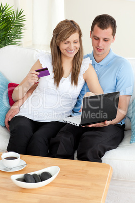 Happy couple using a laptop to buy online