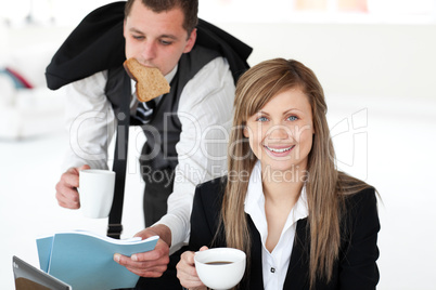 Glowing businesswoman holding a cup smiling at the camera