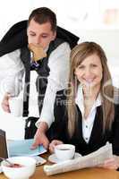 Delighted businesswoman with a cup smiling at the camera