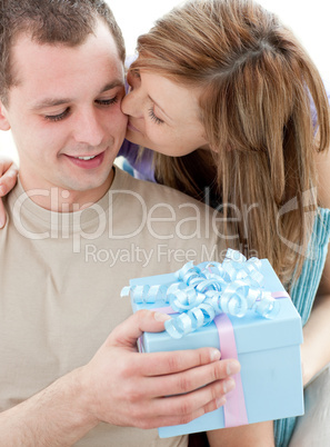 Beautiful girlfriend giving a present and a kiss to his handsome