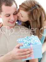Beautiful girlfriend giving a present and a kiss to his handsome