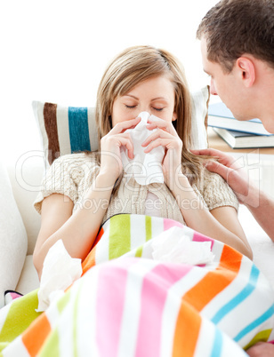 Ill woman with tissue lying on  a sofa