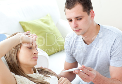 Caring man check the temperature of his sick girlfriend with a t