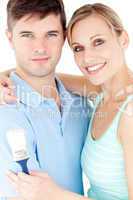 Portrait of a cheerful young couple holding a paint brush