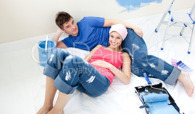 Young couple relaxing after painting a room