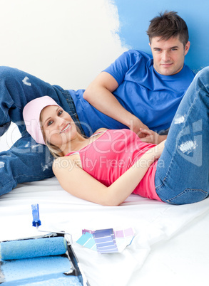 Portrait of a charming couple relaxing after painting a room