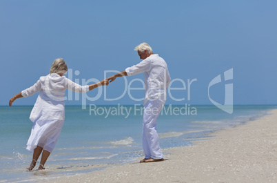 Happy Senior Couple Dancing Holding Hands on A Tropical Beach