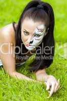 woman with face art on grass