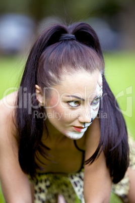 woman with face art on grass