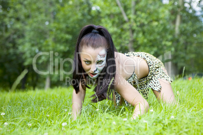 woman with face art on grass