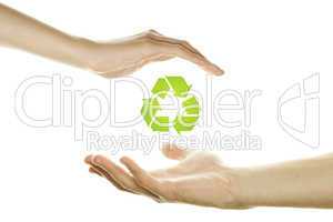 Hands protecting the recycling symbol.