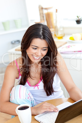 Beautiful Woman using a laptop in the kitchen
